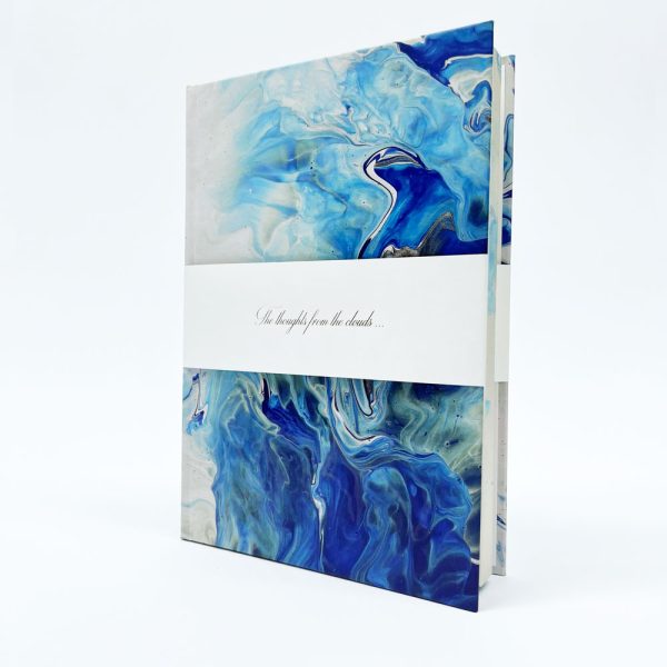 Užrašinė pastatyta, apjuosta balta nuimama juosta, viršelis papuoštas jūros bangomis