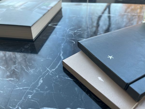 ant stalo dvi užrašinės ir viena darbo knyga